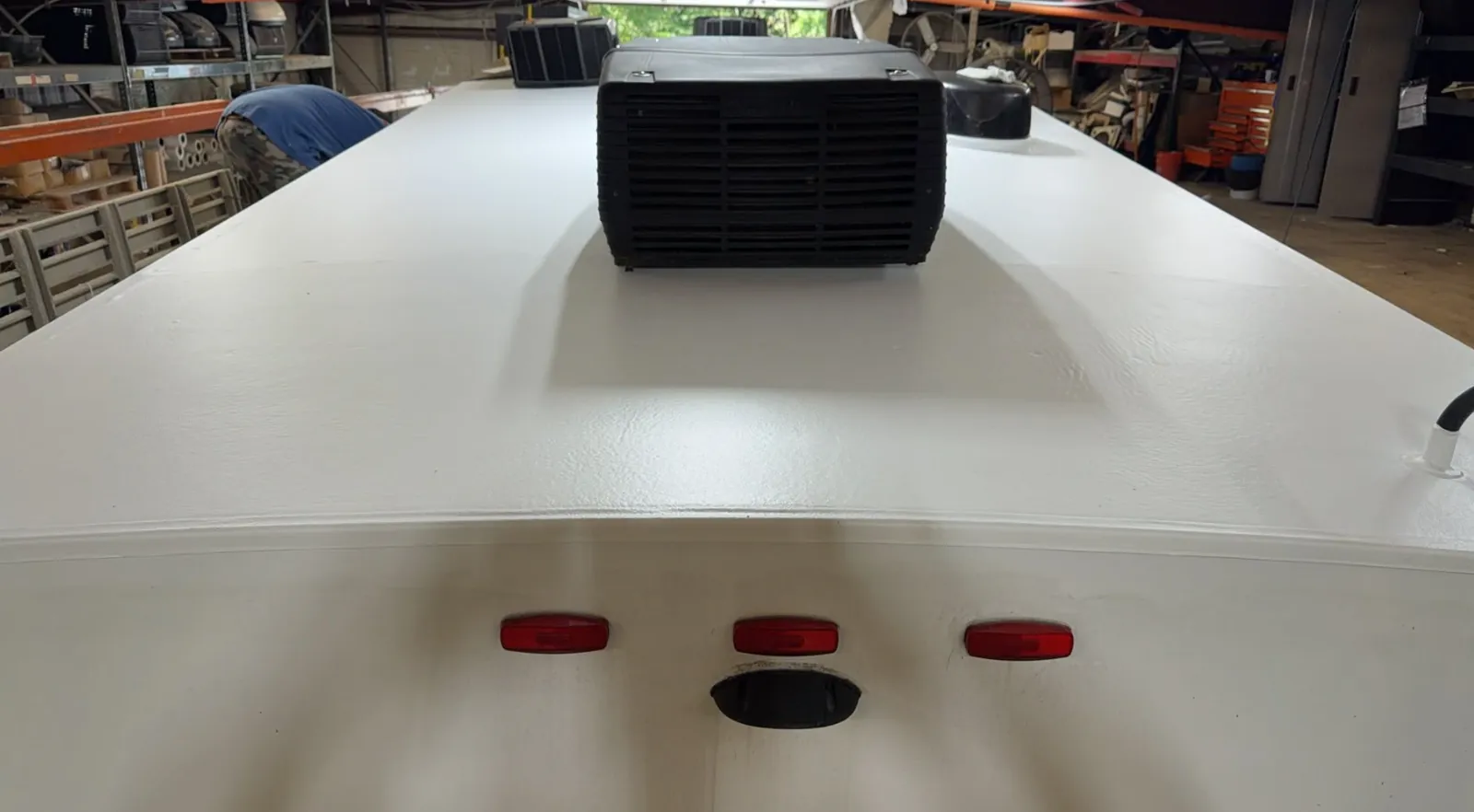Freshly fitted RV roof membrane in a workshop with the air conditioner shroud refitted
