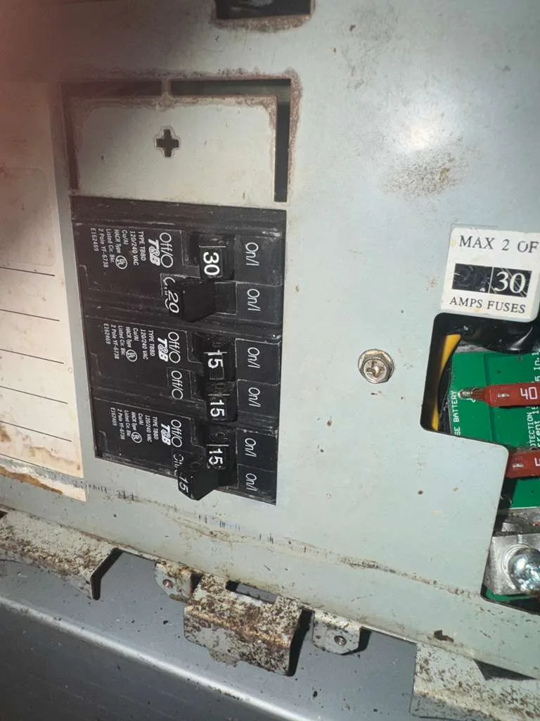 RV breaker panel with 30, 20 and 15 amp breakers and a fuse rating label